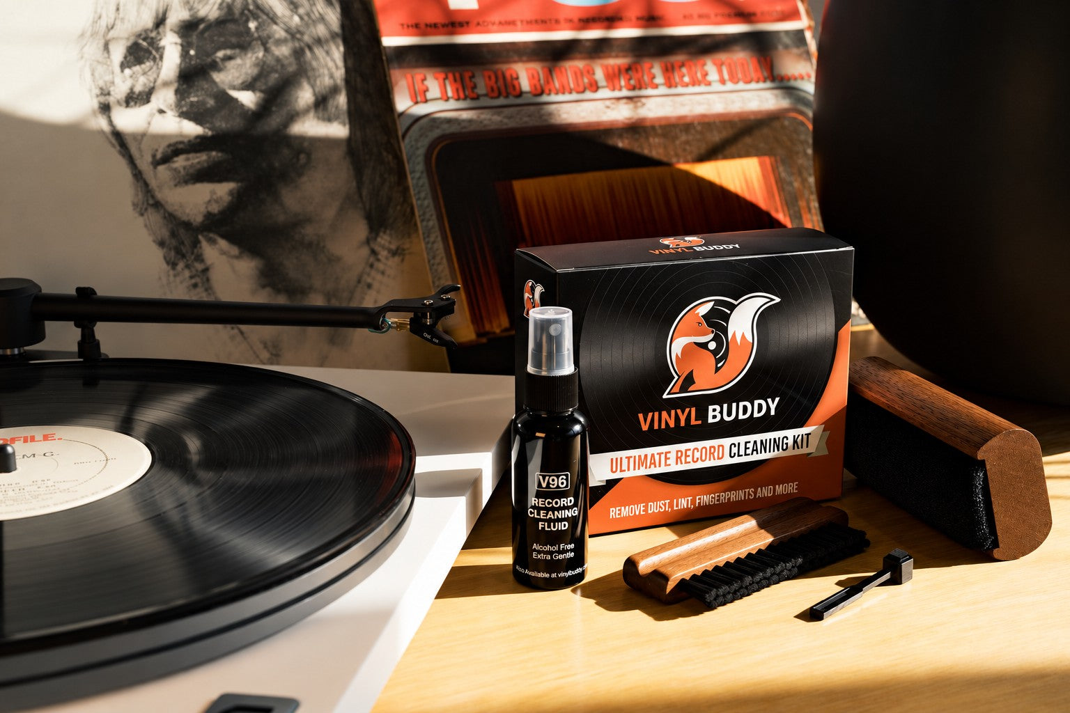 Vinyl Buddy 5-in-1 Record Cleaning Kit with velvet brush, nylon brush, stylus brush and V96 cleaning fluid beside a turntable