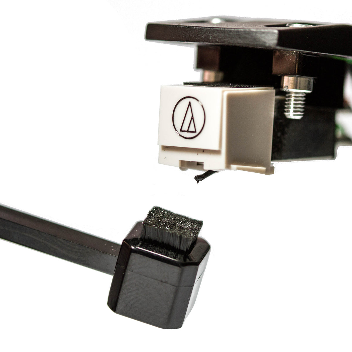 Vinyl Buddy microfiber stylus cleaner brush next to a turntable cartridge and needle