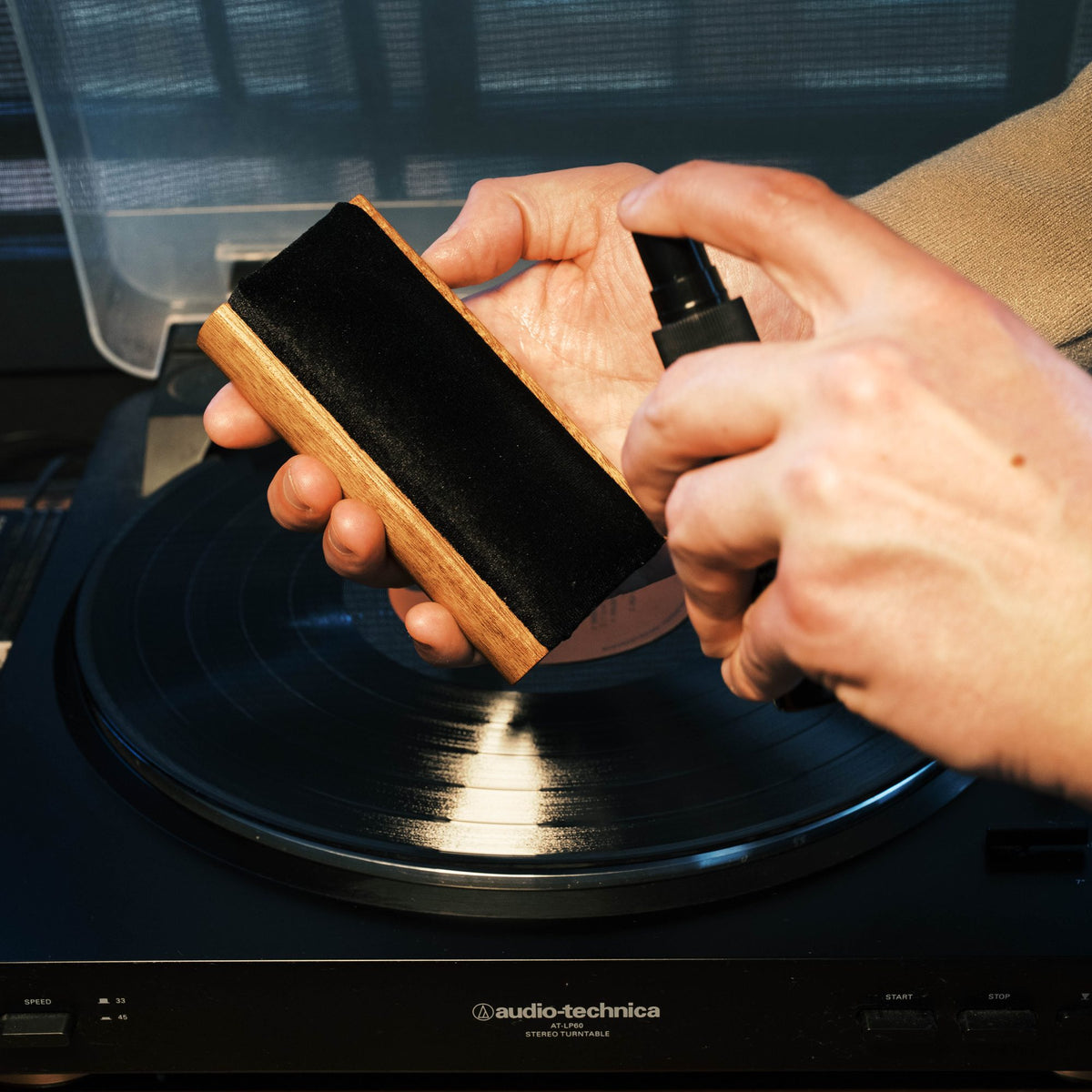 Misting Vinyl Buddy cleaning solution onto a velvet record brush